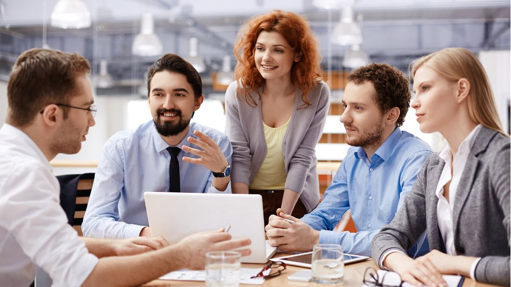 Small business team discussing Ai Marketing agency tools, blending traditional and digital strategies in a collaborative workspace